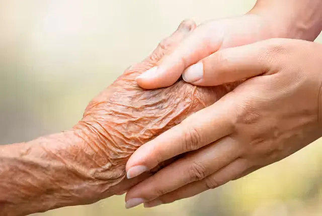 Junge Hand hält die Hand eines älteren Menschen